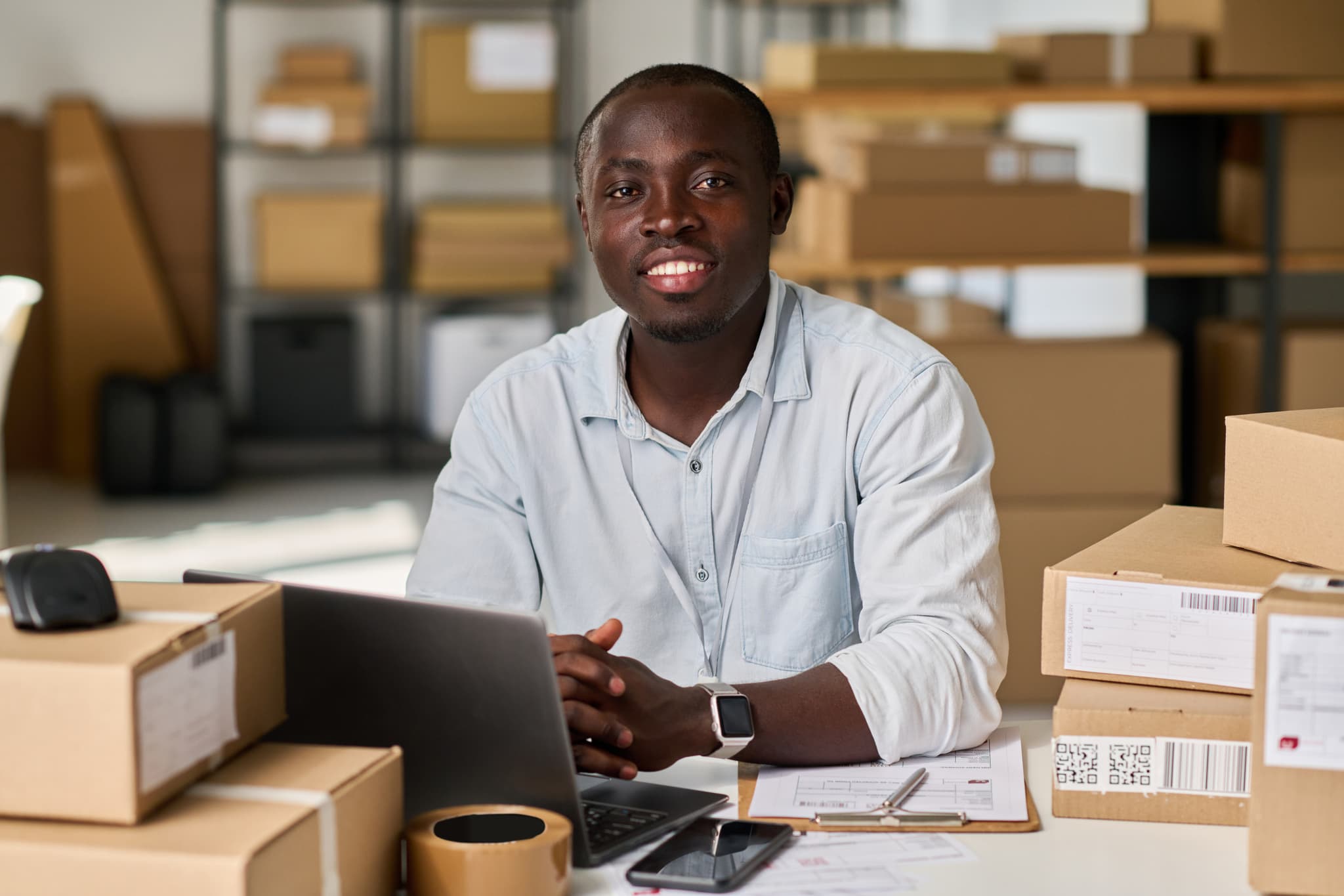 Propriétaire d’un entrepôt devant ses marchandises